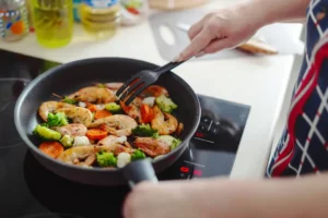 femme qui cuisine malin avec une seule poele